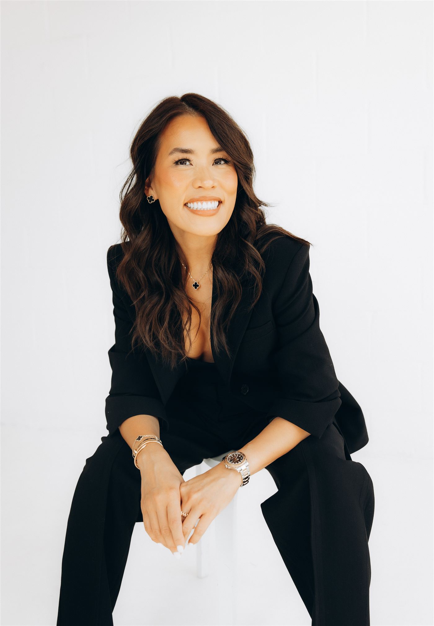 Anna Hong, smiling, seated with her hands folded